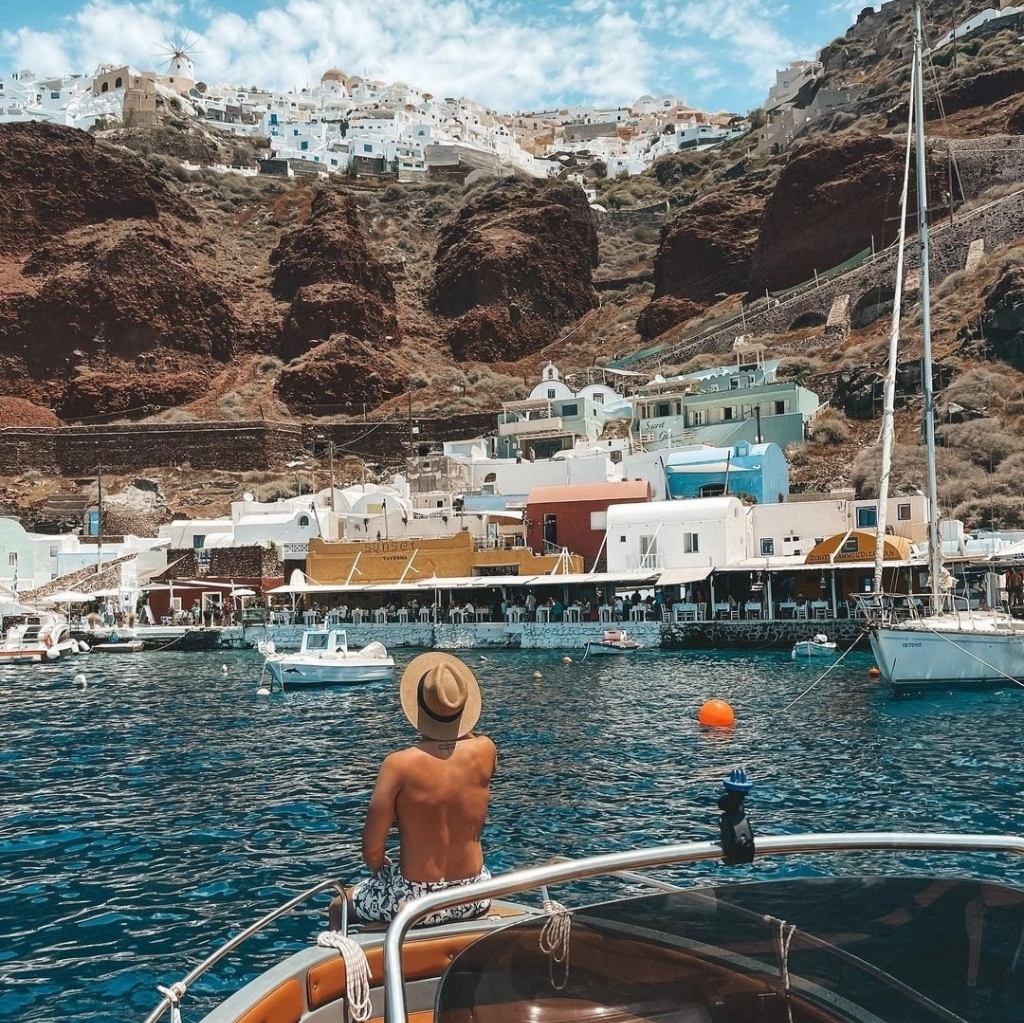 Enjoying the view of Ammoudi Bay and Oia from a luxurious self-drive motorboat during the Freedom Cruise by Seascape Santorini – a license-free private boat rental perfect for exploring Santorini’s coastline and charming ports at your own pace.